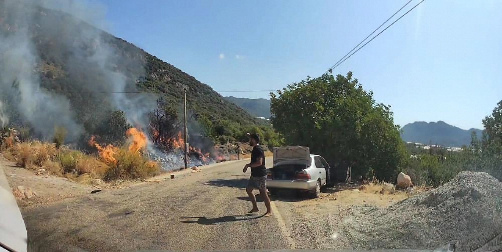 Yol kenarındaki yangını gören tatilci aile alevlere yangın tüpüyle müdahale etti