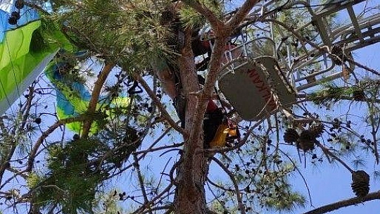 Ağaçta asılı kalan yamaç paraşütçülerini itfaiye kurtardı