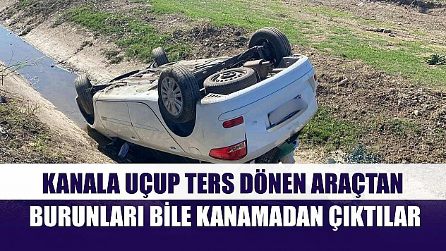 Kanala uçup ters dönen araçtan burunları bile kanamadan çıktılar