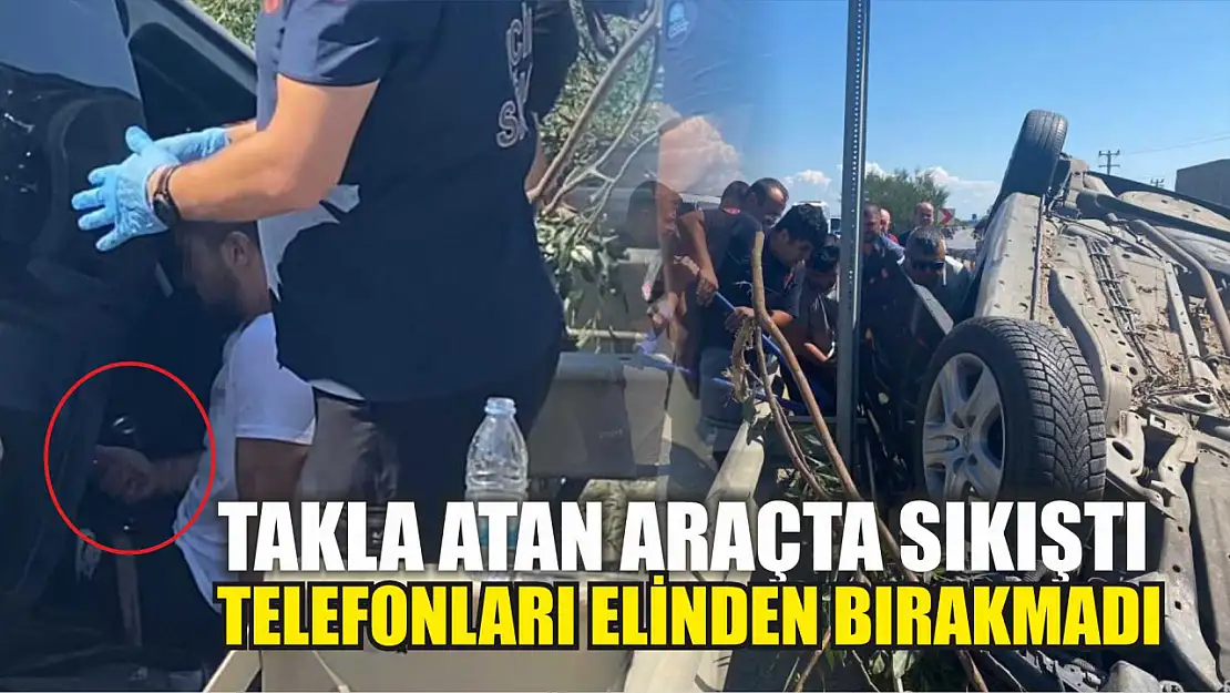 Takla atan araçta sıkıştı, telefonları elinden bırakmadı