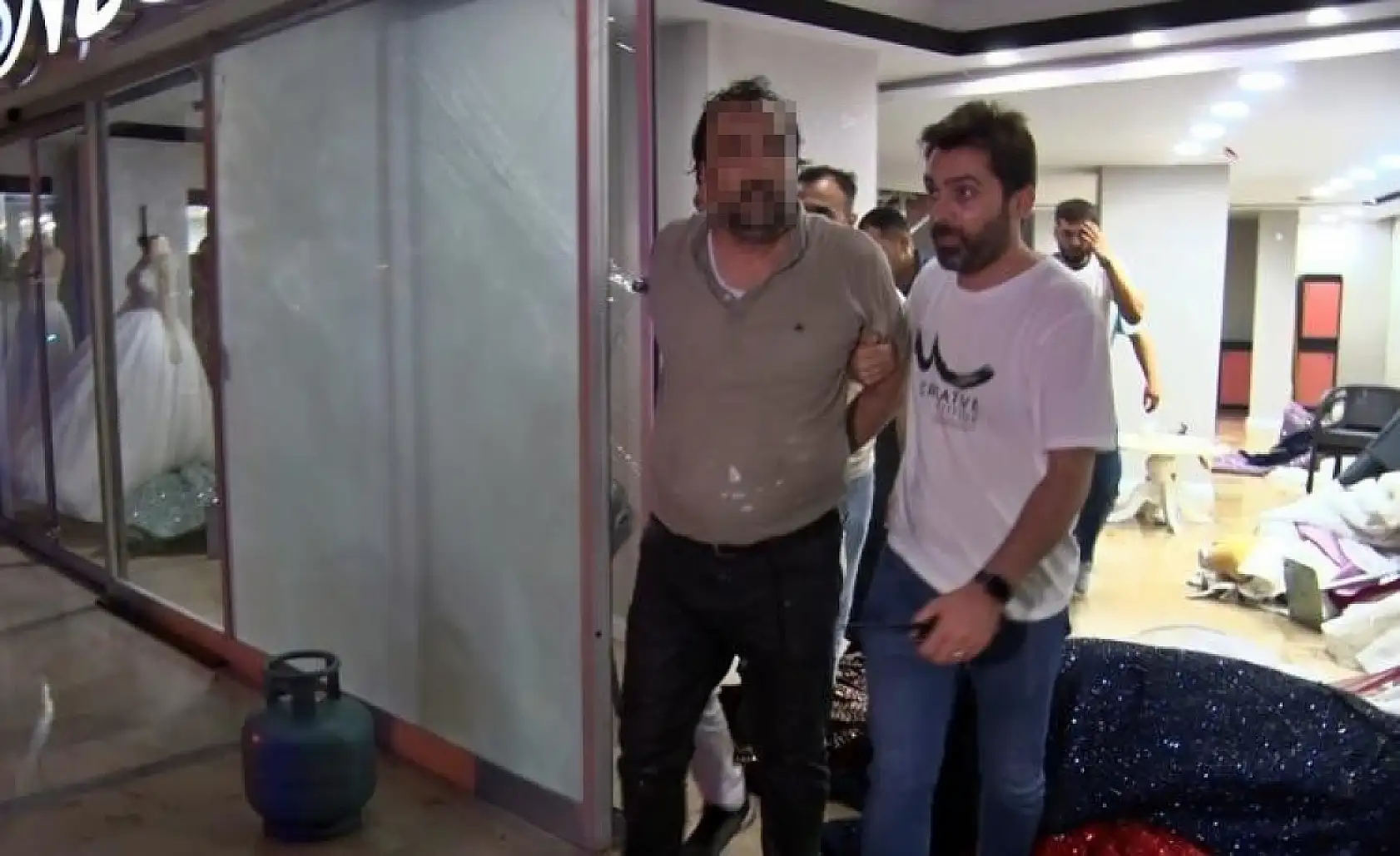 Eşinin mağazasına girip gelinliklerin üzerlerine kolonya döktü, tüpe çakmağı dayayınca tazyikli suyu yedi