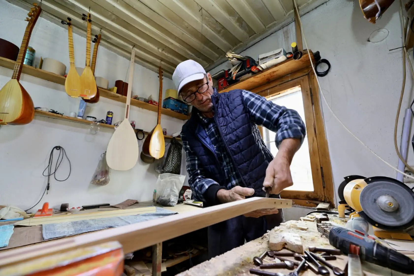 Seydikemerli Orhan usta 37 yıldır 5 metrekarelik atölyesinde bağlama ve cura üretiyor