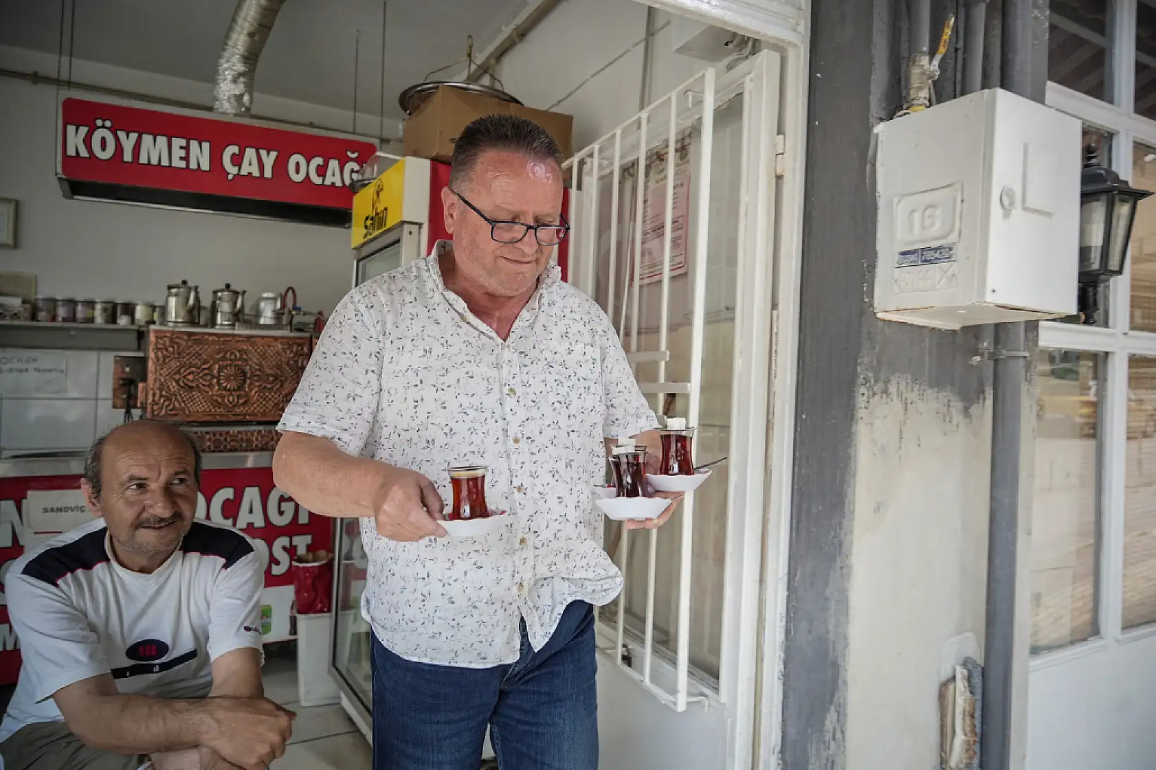 50 metre uzaklıktaki çay ocağından aldığı çayları otomobiliyle taşıyor