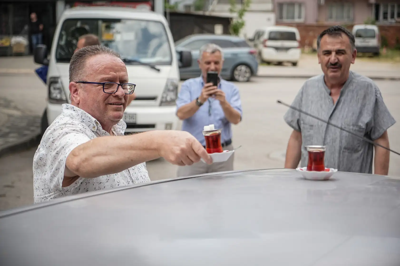 50 metre uzaklıktaki çay ocağından aldığı çayları otomobiliyle taşıyor