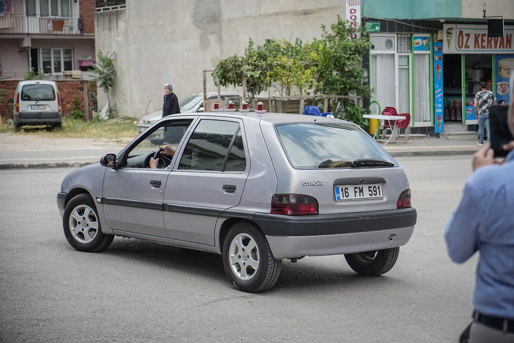 50 metre uzaklıktaki çay ocağından aldığı çayları otomobiliyle taşıyor