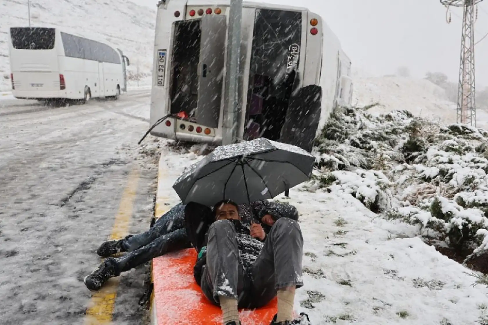 Kaza sonrası sağlık ekiplerini şemsiye ile yatarak bekledi