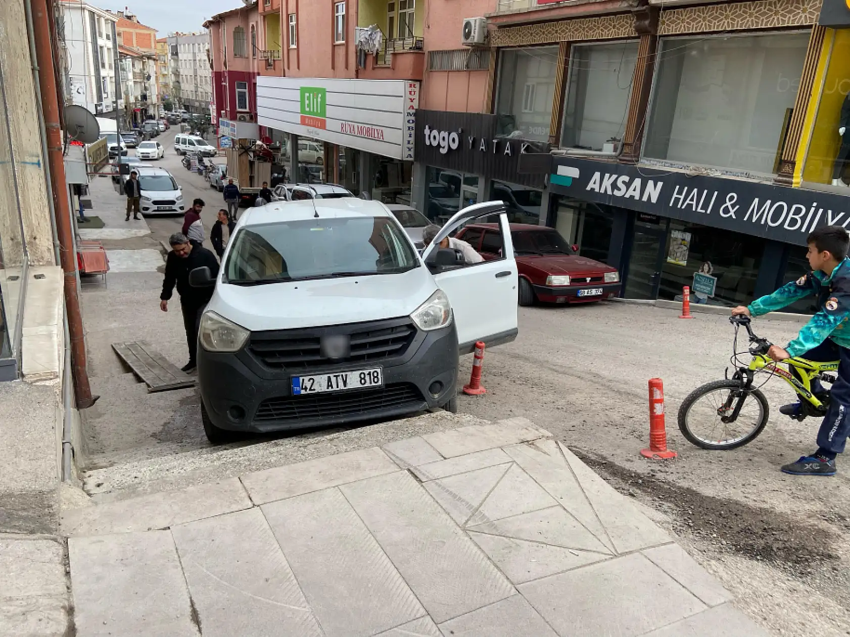 Geri manevra yapan hafif ticari araç yokuştaki merdivenli kaldırıma düştü