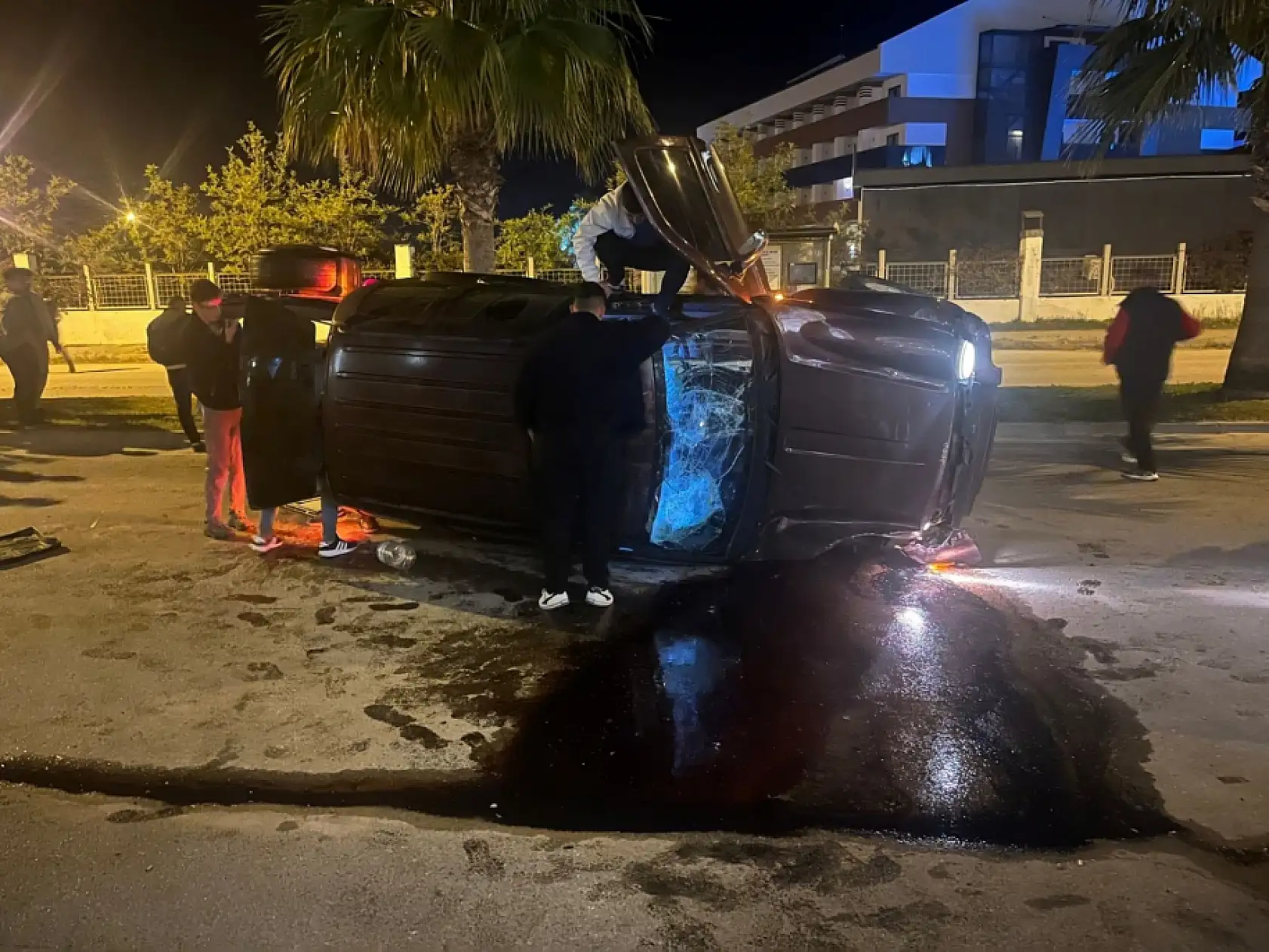 Devrilen otomobildekilerin çıkarılma anlarını film izler gibi izlediler