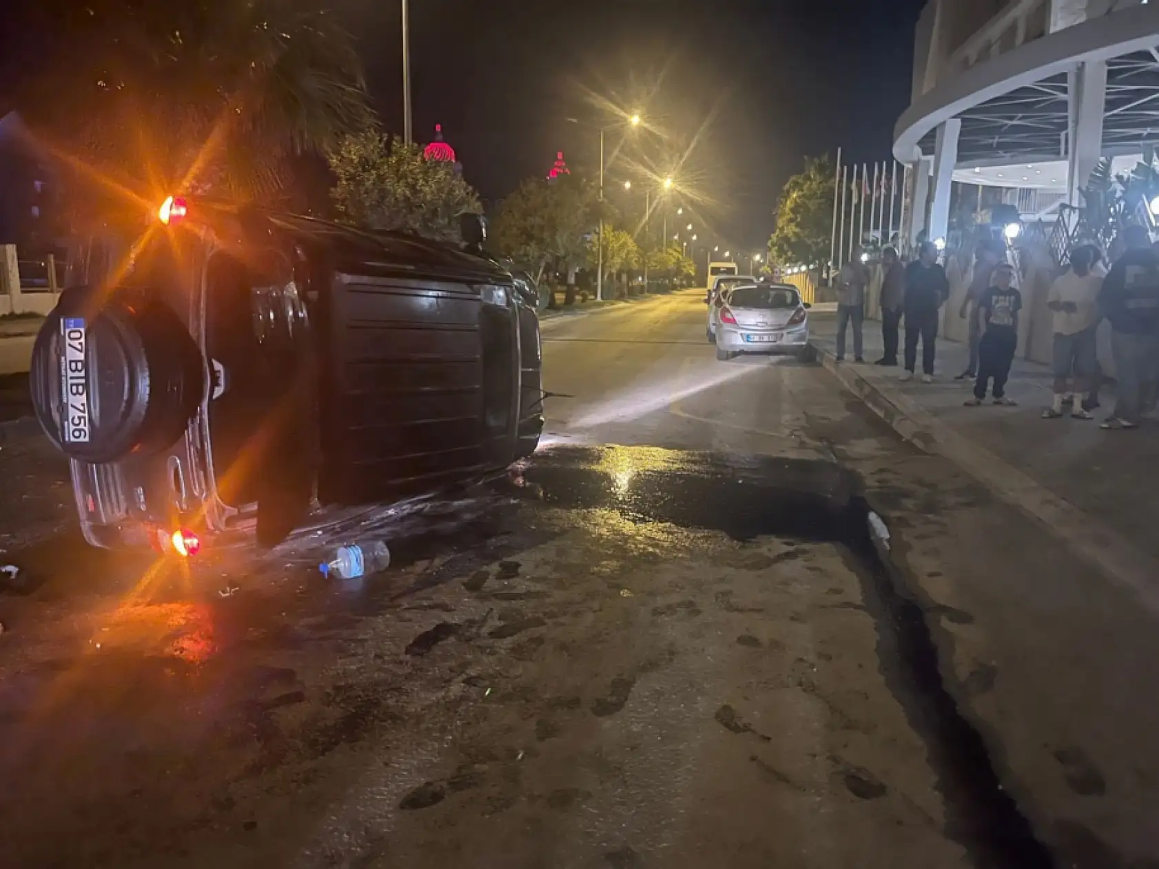 Devrilen otomobildekilerin çıkarılma anlarını film izler gibi izlediler