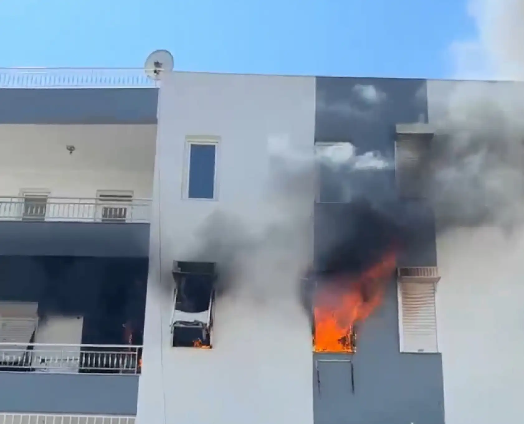 Alevlerin sardığı evde balkona sığındı, kedisini elinden bırakmadı