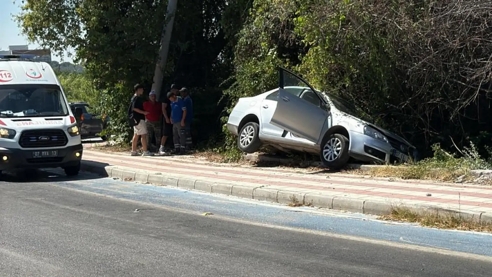 Kaldırıma çıkıp asılı kalan otomobildekiler kazayı burnu bile kanamadan atlattı
