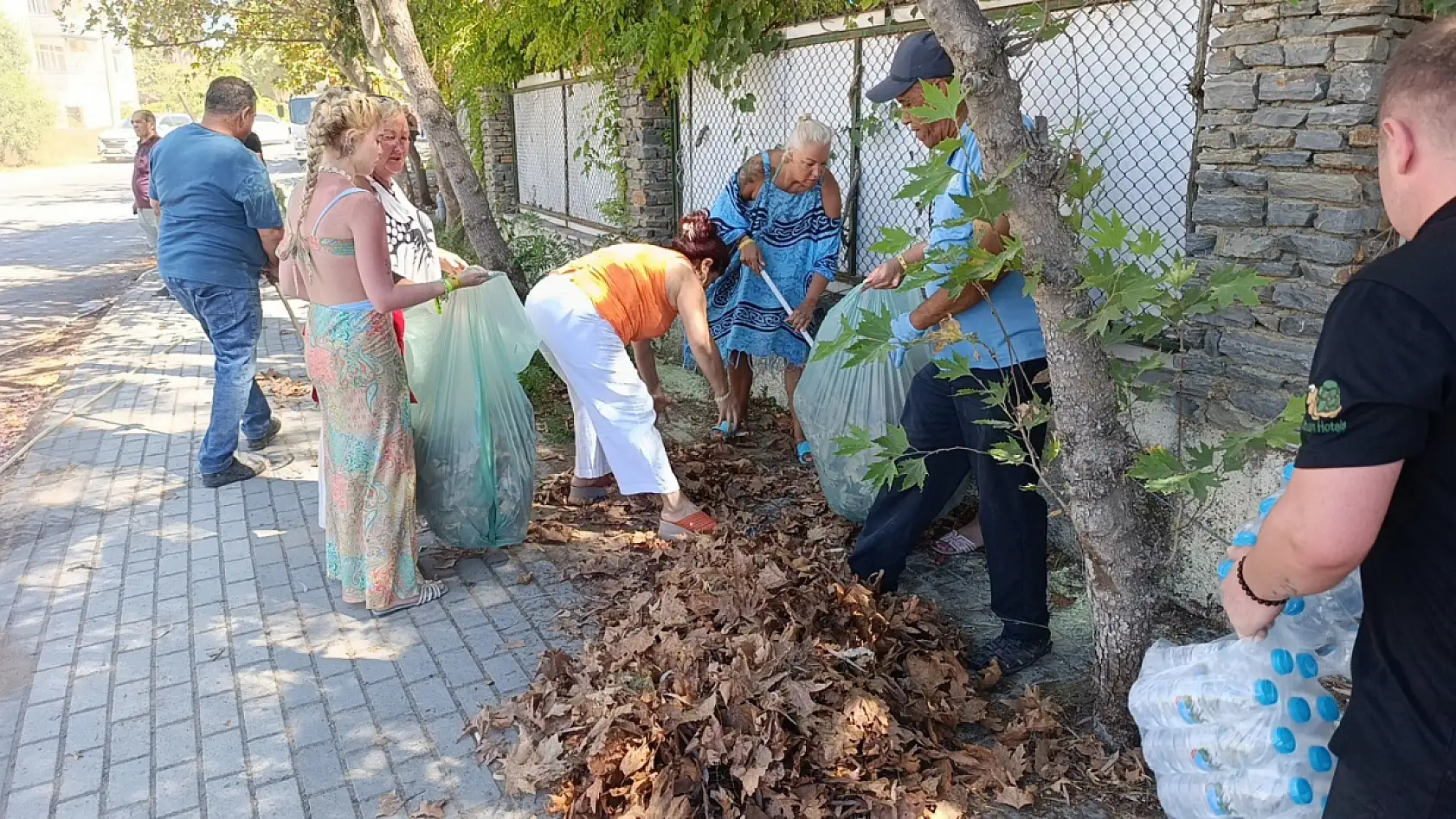 Turistler yangın sonrası otel çevresindeki kurumuş ot ve yaprakları temizledi