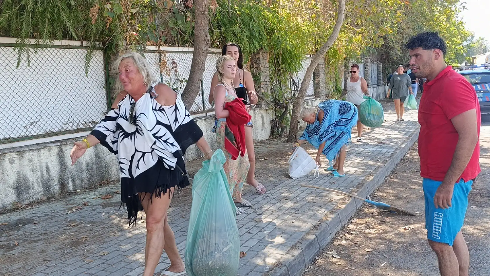 Turistler yangın sonrası otel çevresindeki kurumuş ot ve yaprakları temizledi