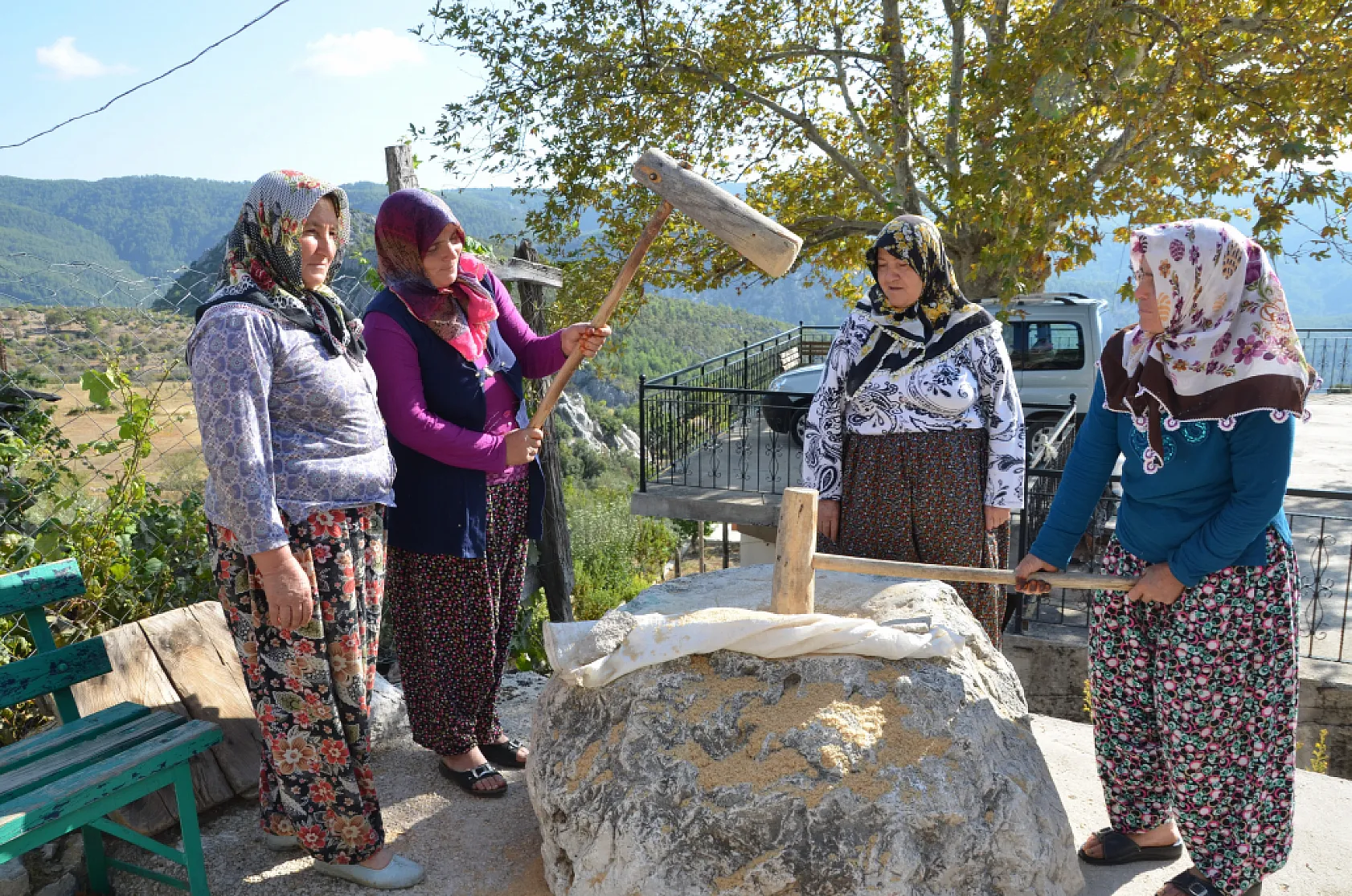 Asırlık dibek taşında buğday dövüp bir taraftan ise erişte ve çorbalık kesiyorlar