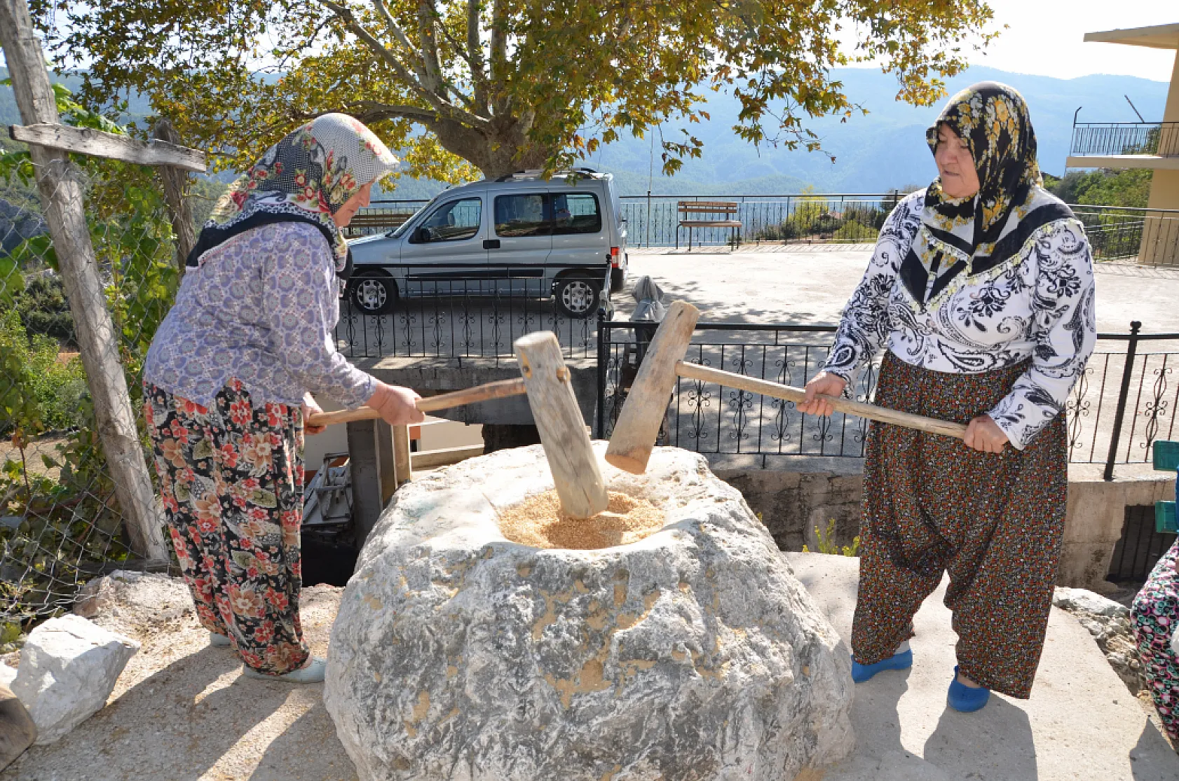 Asırlık dibek taşında buğday dövüp bir taraftan ise erişte ve çorbalık kesiyorlar