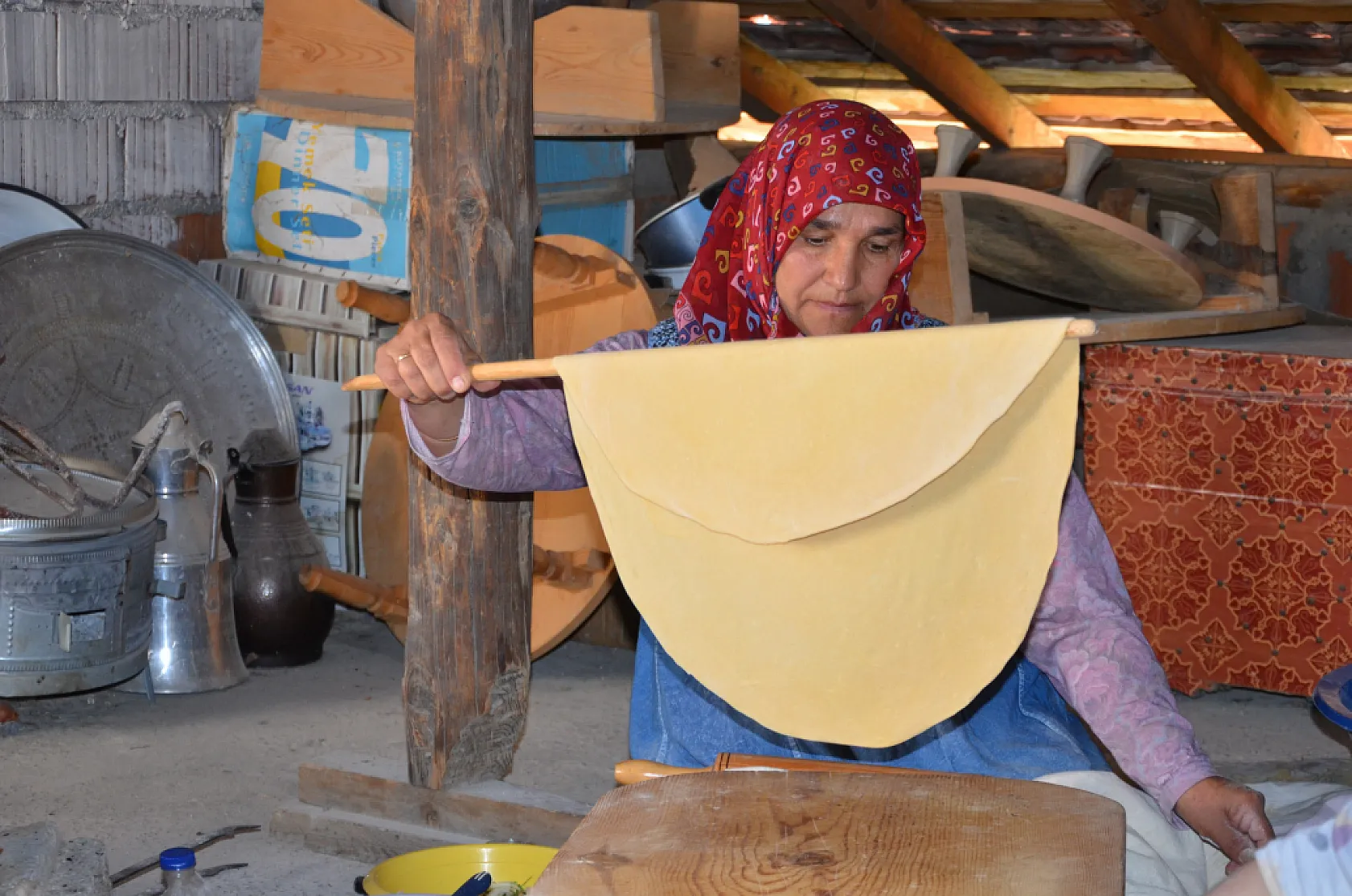 Asırlık dibek taşında buğday dövüp bir taraftan ise erişte ve çorbalık kesiyorlar