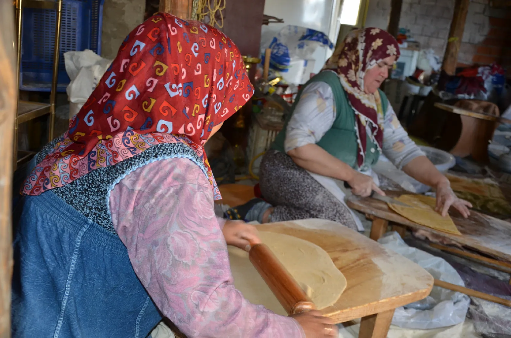 Asırlık dibek taşında buğday dövüp bir taraftan ise erişte ve çorbalık kesiyorlar
