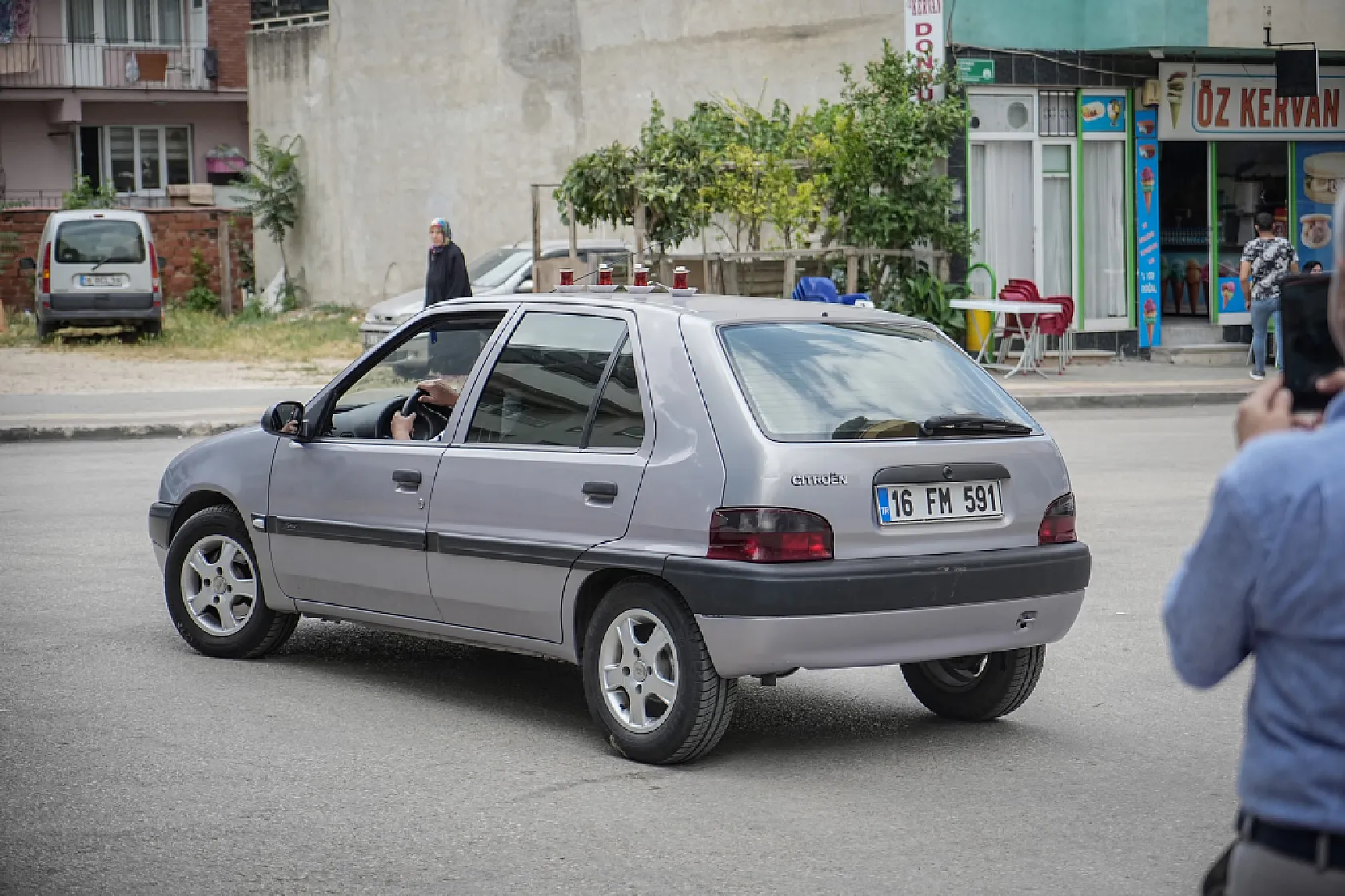 50 metre uzaklıktaki çay ocağından aldığı çayları otomobiliyle taşıyor