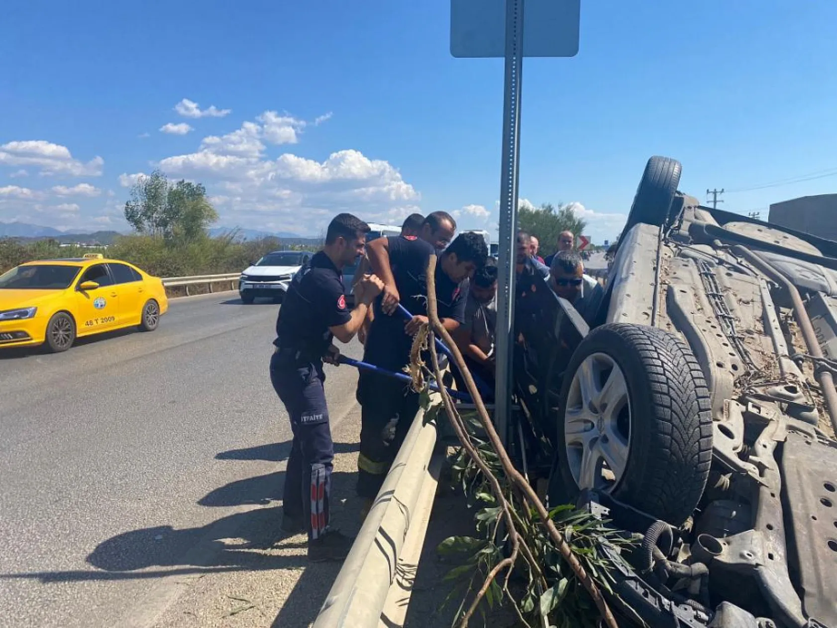 Takla atan araçta sıkıştı, telefonları elinden bırakmadı