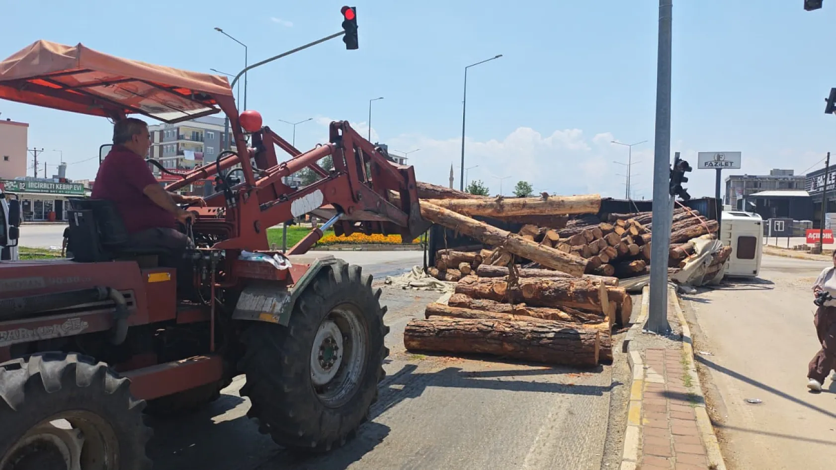 Kamyon kavşağa girerken devrildi, tomruklar yola savruldu