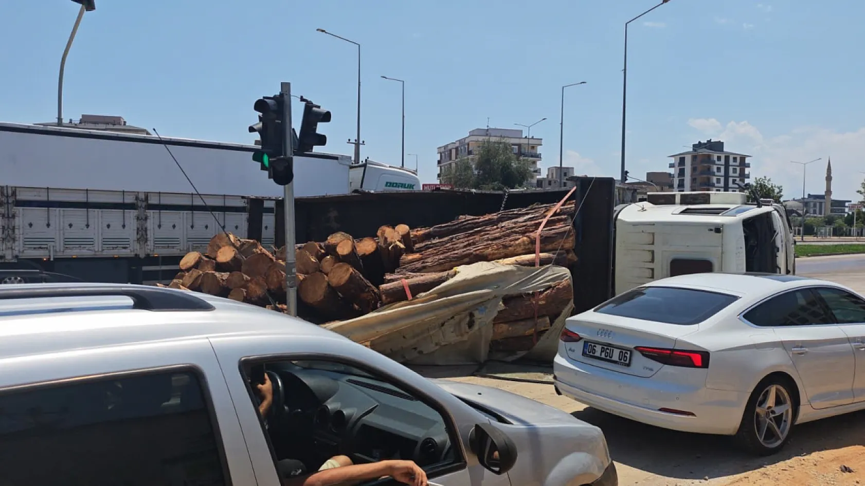Kamyon kavşağa girerken devrildi, tomruklar yola savruldu