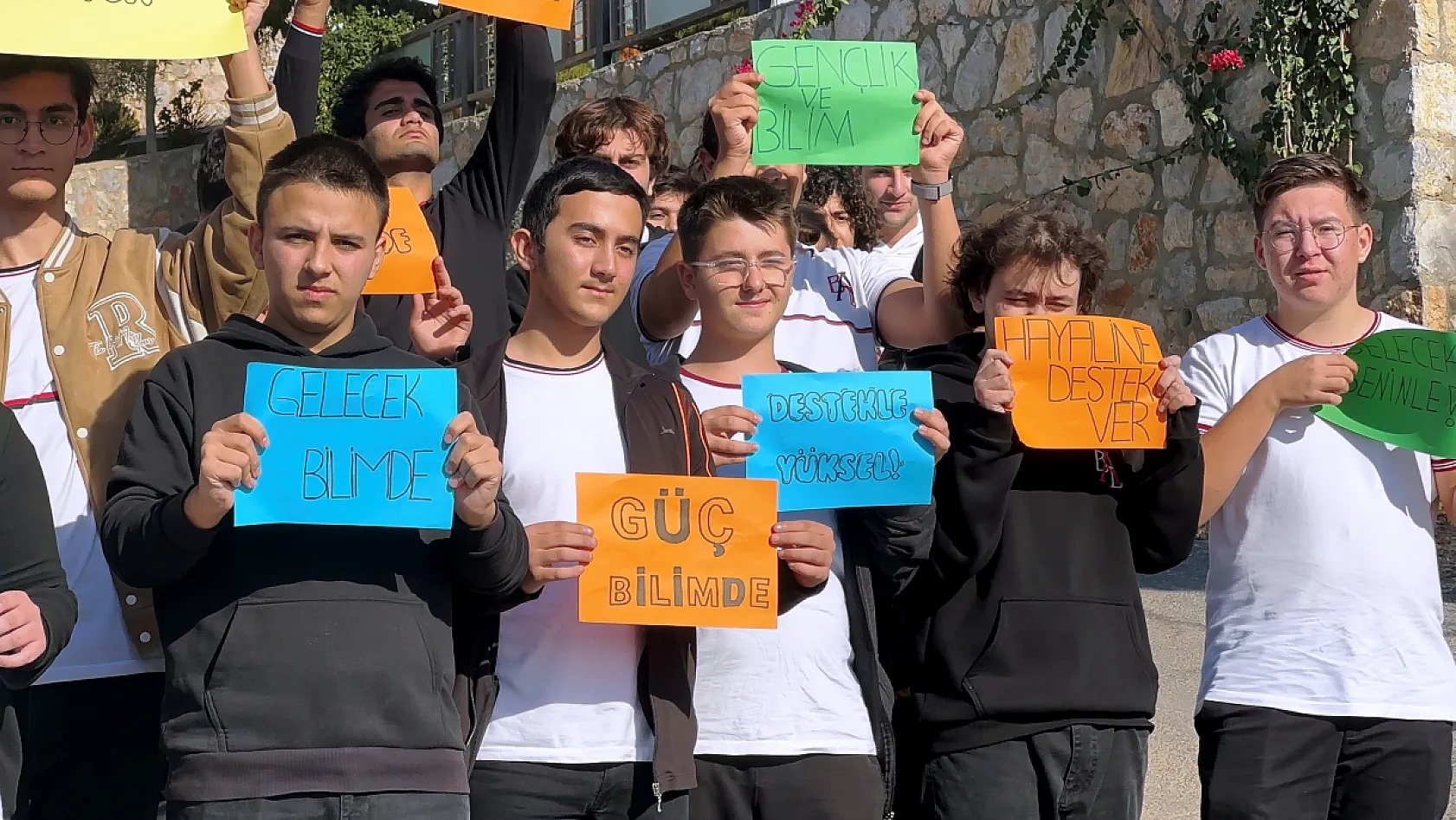 Öğrenciler ellerinde pankartlarla yarışmaya katılmak için destek istedi