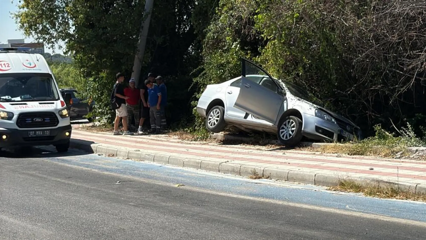 Kaldırıma çıkıp asılı kalan otomobildekiler kazayı burnu bile kanamadan atlattı