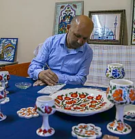 Fethiye'de odasını atölyeye dönüştüren bedensel engelli sanatçı 20 yıldır çini boyuyor