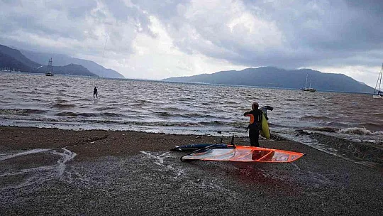 Sağanak yağışa aldırmadan denizde sörf yaptı