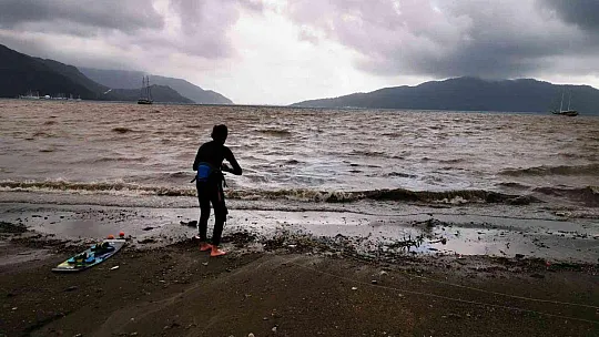 Sağanak yağışa aldırmadan denizde sörf yaptı