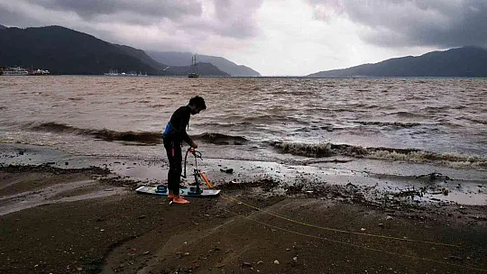 Sağanak yağışa aldırmadan denizde sörf yaptı