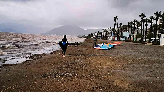 Sağanak yağışa aldırmadan denizde sörf yaptı