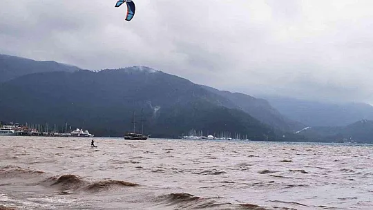 Sağanak yağışa aldırmadan denizde sörf yaptı