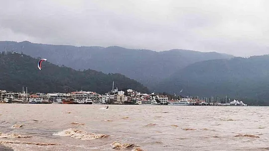 Sağanak yağışa aldırmadan denizde sörf yaptı