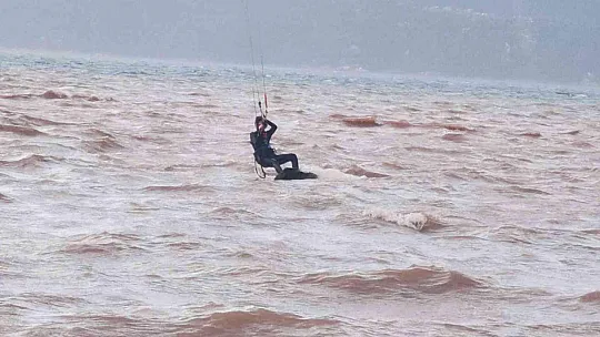 Sağanak yağışa aldırmadan denizde sörf yaptı