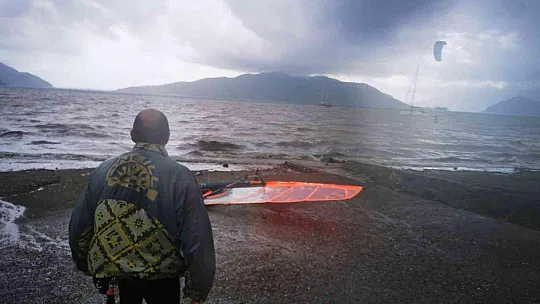 Sağanak yağışa aldırmadan denizde sörf yaptı