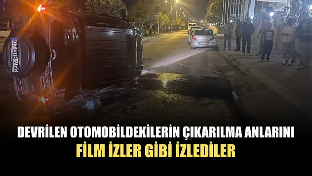 Devrilen otomobildekilerin çıkarılma anlarını film izler gibi izlediler