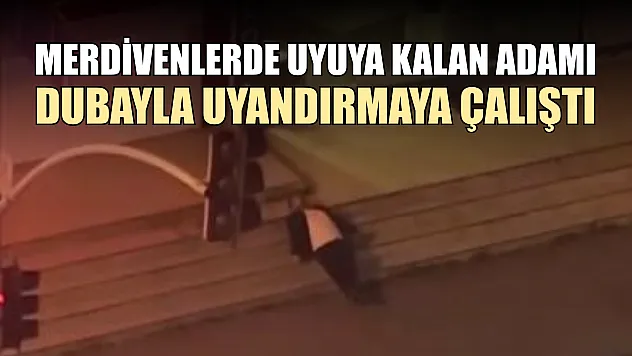 Merdivenlerde uyuya kalan adamı dubayla uyandırmaya çalıştı